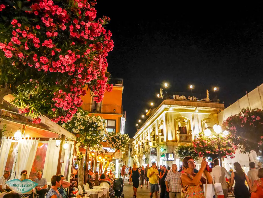 Light and vibrant flower lit up the street of Taormina after dark at Corso Umbreto | Laugh Travel Eat