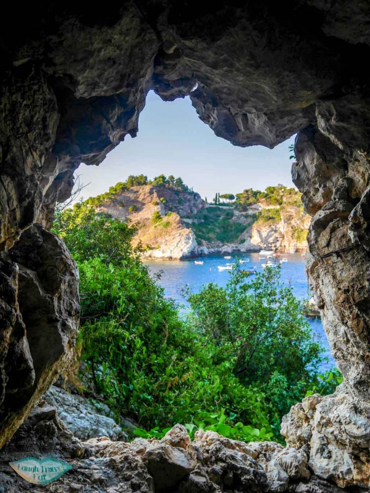 Peeking through a window through Isola Bella, Taormina | Laugh Travel Eat
