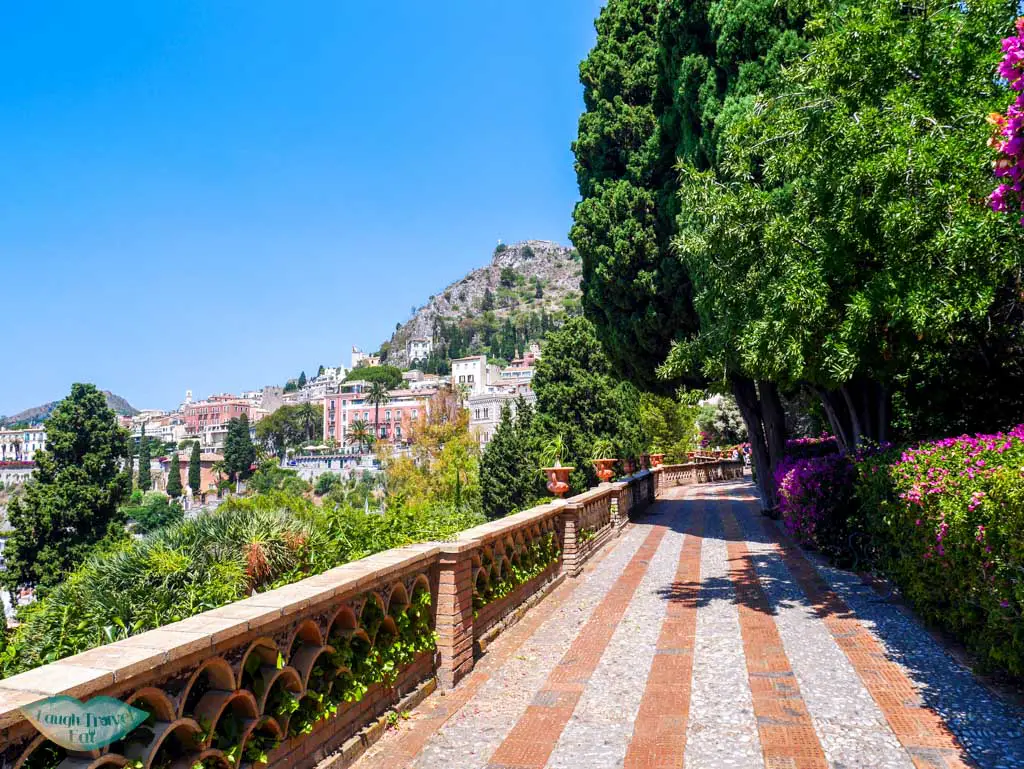The beautiful public Garden of Villa Comunale in Taormina, Italy with a gorgeous view and colourful flowers | Laugh Travel Eat