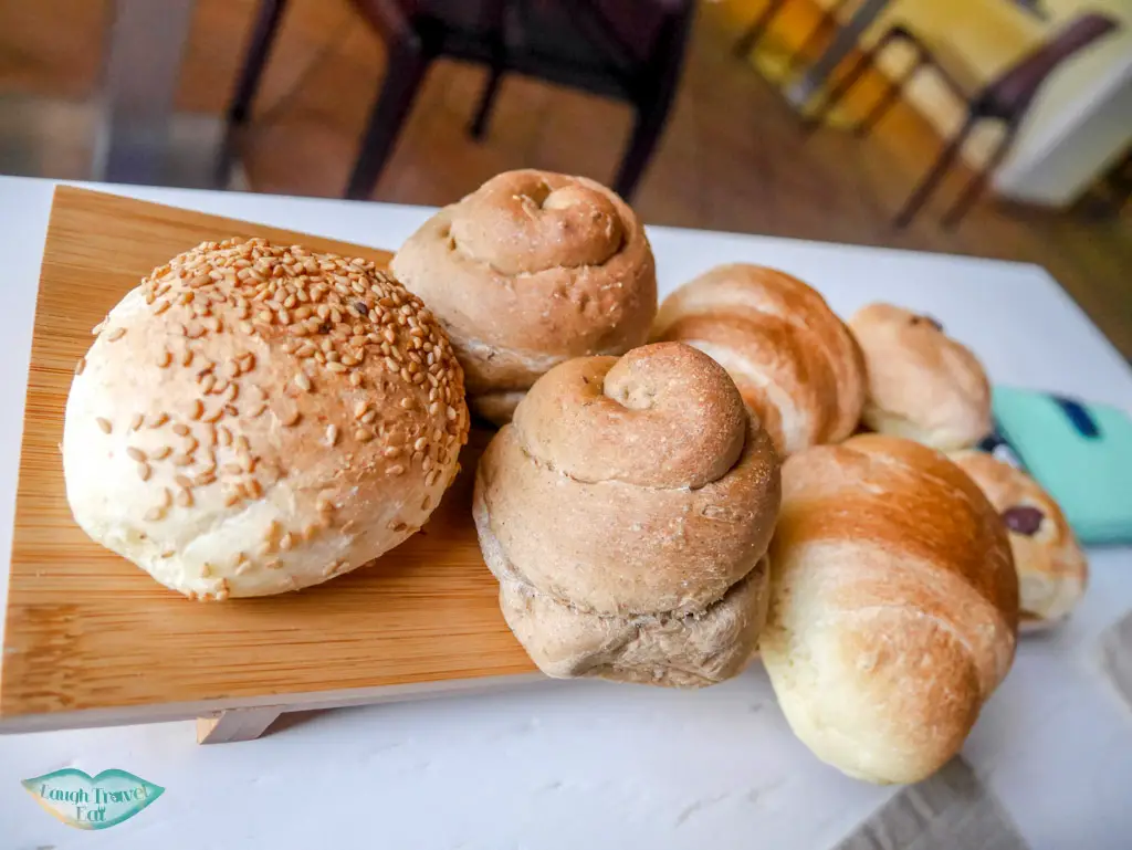 complimentary assorted bread plate on a wooden board at Flam Osteria in Palermo | Laugh Travel Eat
