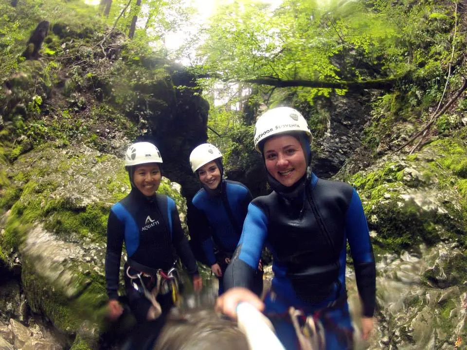 Canyoning shot of me and 2 girls in our wet suit and safety helmet | Laugh Travel Eat