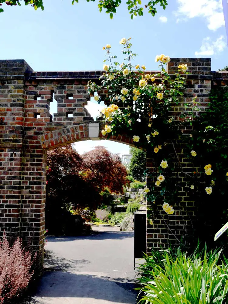 A random brick gate overgrown with flowers, Kew Garden, London, UK | Laugh Travel Eat