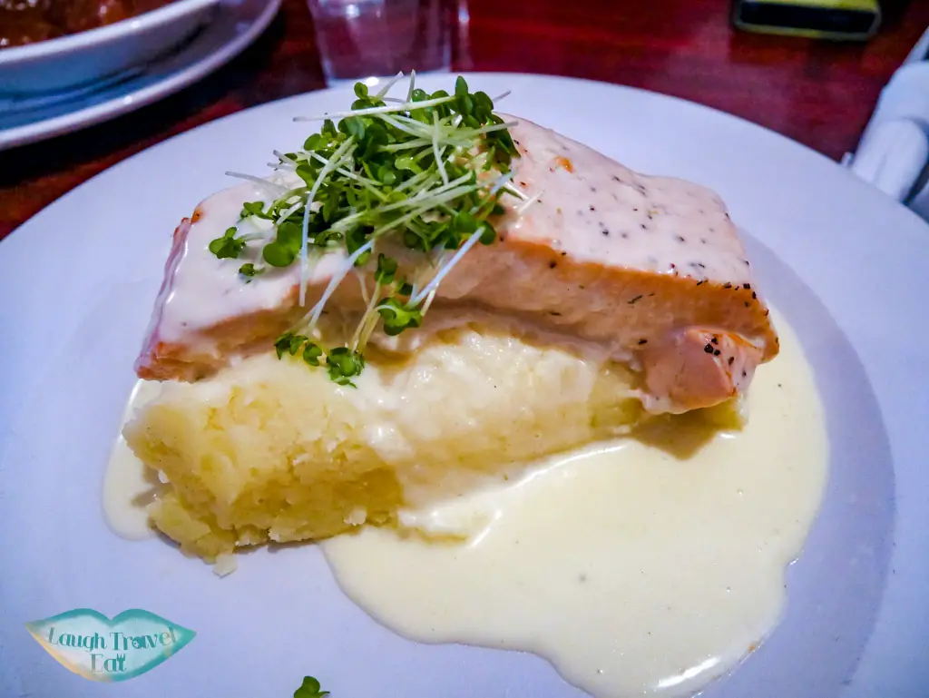 Salmon-on-top-of-mashed-potatoes-coupled-with-creamy-white-sauce-Gus-O’Connor’s-Pub-rail-tour-dublin-Ireland-Laugh-Travel-Eat