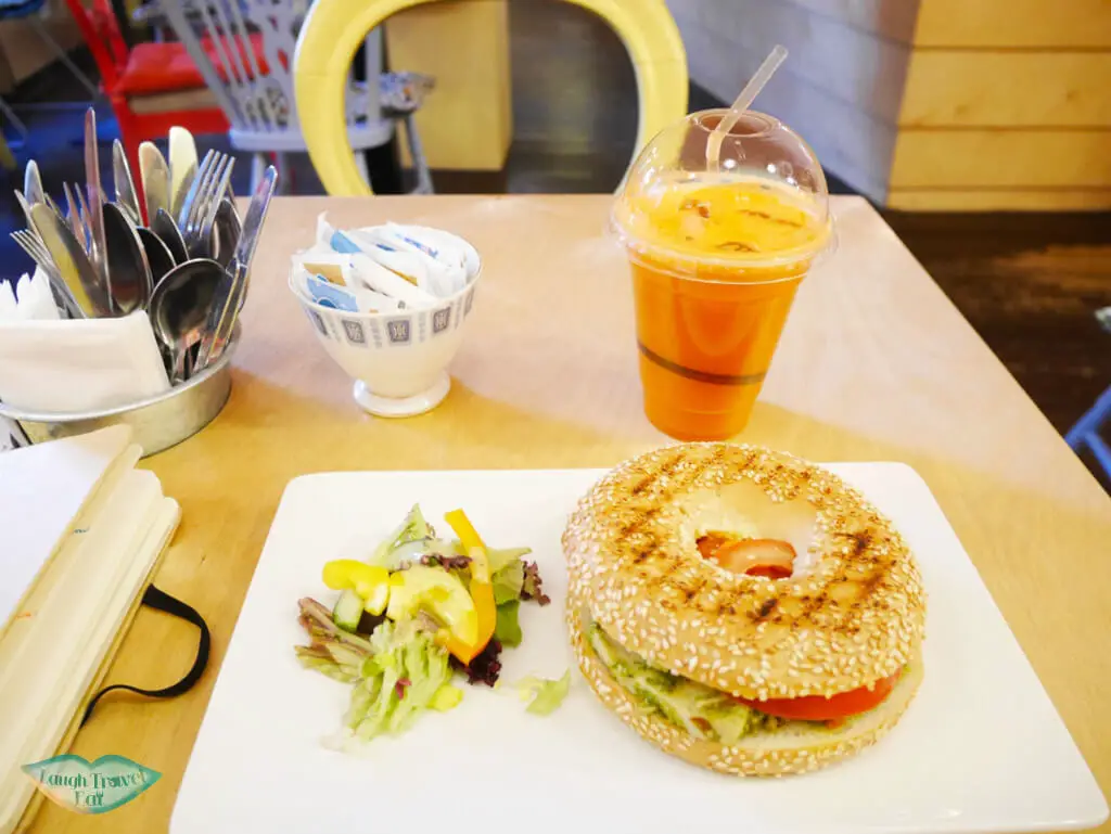 Sun-dried tomato with chicken bagel, coupled with carrot juice at Hula Juice Bar, Edinburgh - Laugh Travel Eat