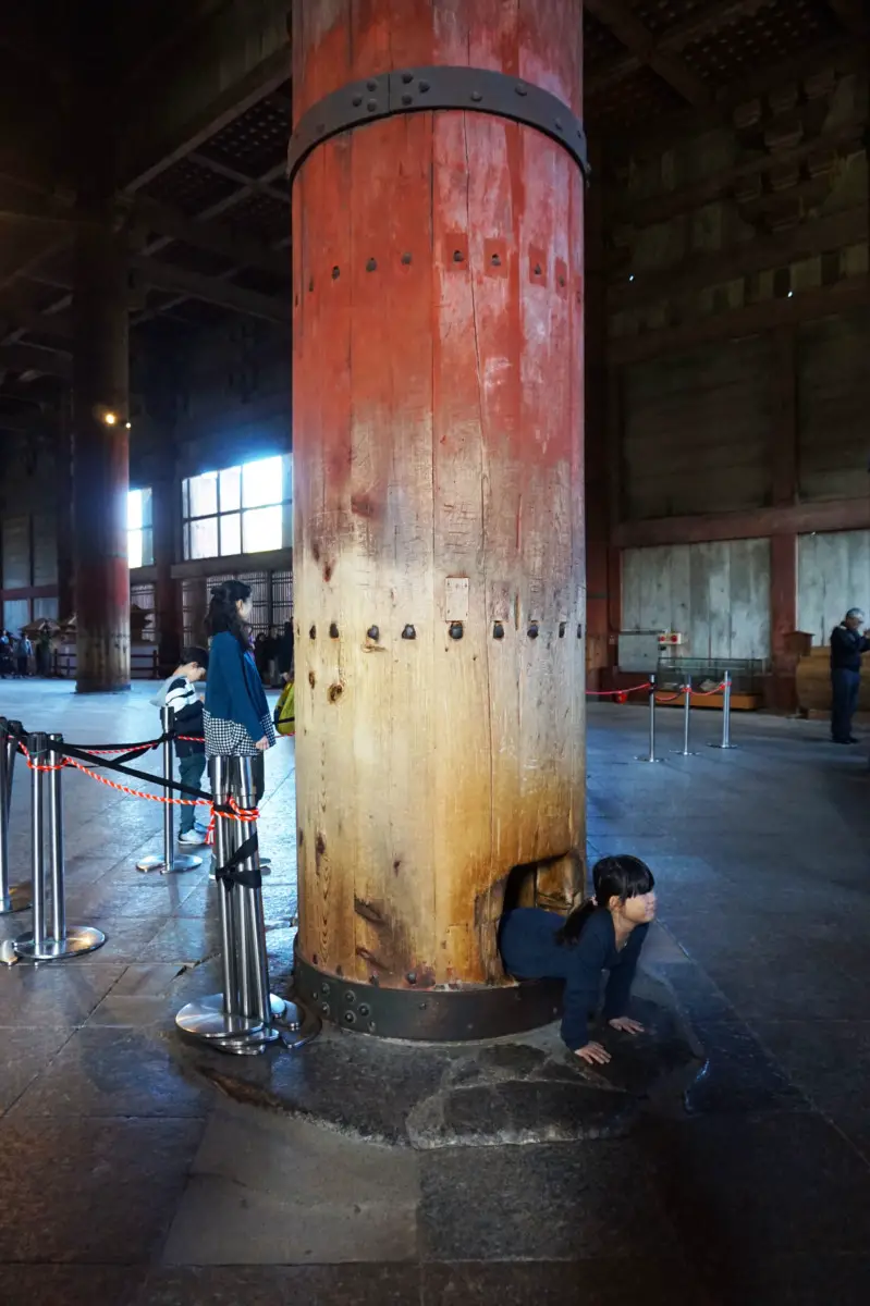 Hole in a pillar with a child climbing through inside Todaiji Temple, Nara, Japan | Laugh Travel Eat