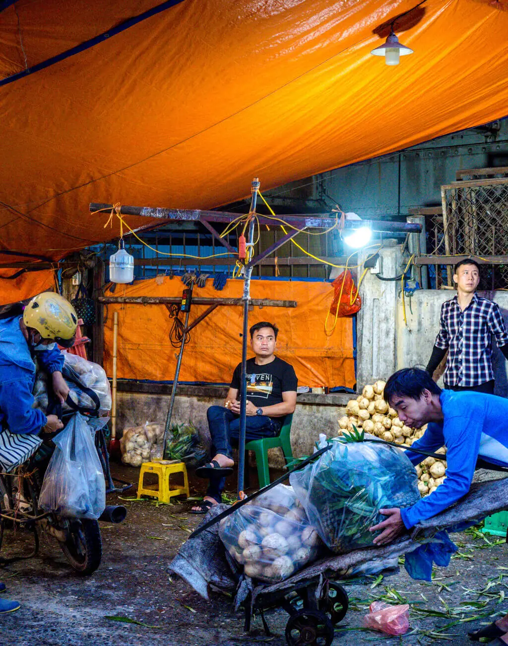 man at outdoor market wholesale market a chef's tour Hanoi Vietnam - laugh travel eat