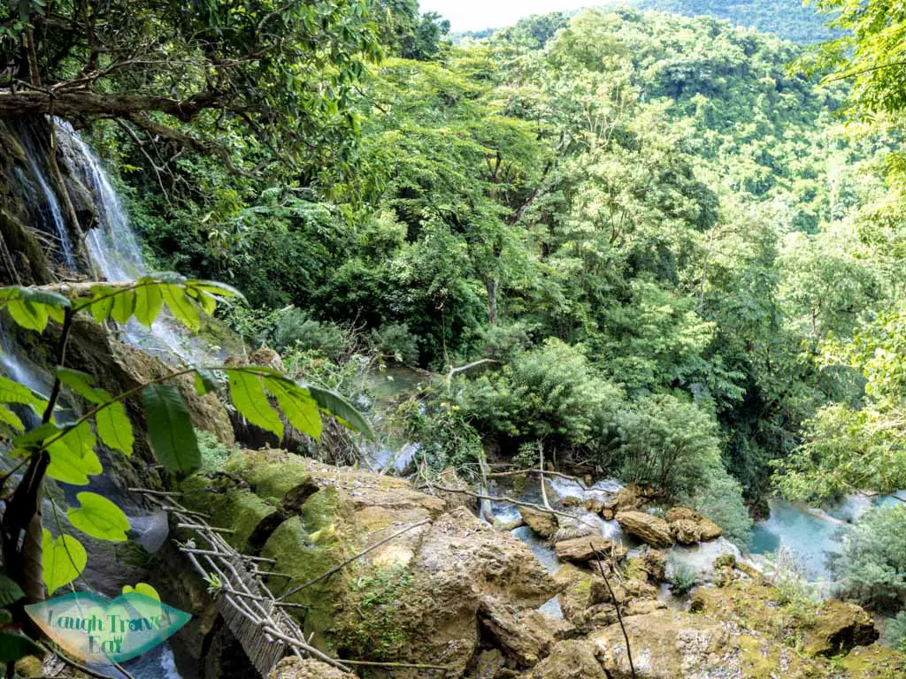 view of main waterfall from top kuang si waterfall luang prabang laos - laugh travel eat