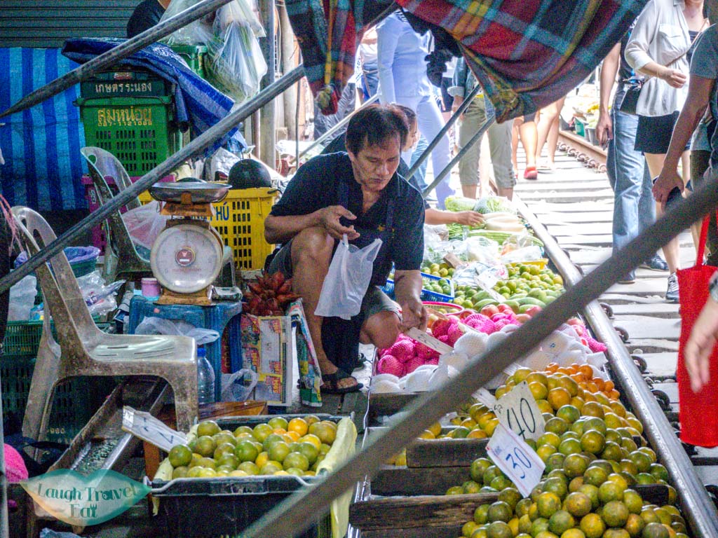 man-selling-fruitsmekong-railway-market-bangkok-thailand-laugh-travel-eat
