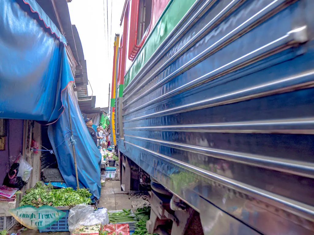train-passing-maeklong-railway-market-bangkok-thailand-laugh-travel-eat