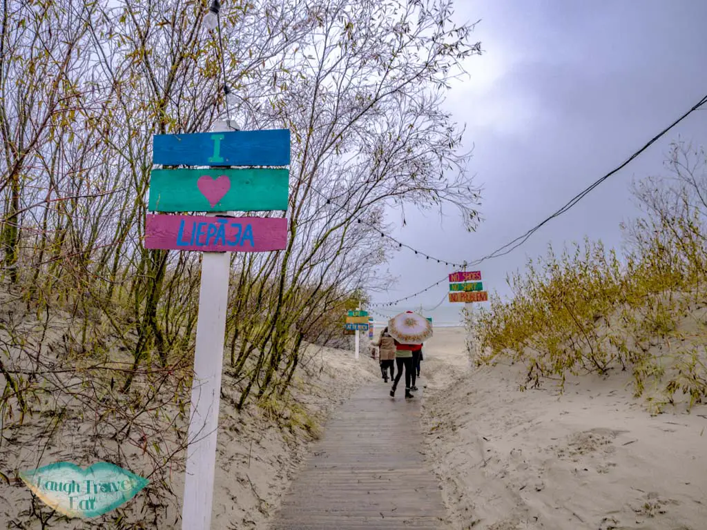 entry to the white sand beach liepaja latvia - laugh travel eat