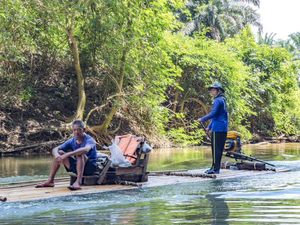 local passing by bamboo raft with khao sok lake khao sok national park Thailand - laugh travel eat