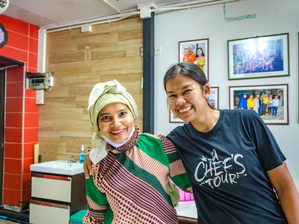 our guide Nam and the daughter of curry stall owner a chefs tour southern flavours phuket town thailand laugh travel eat