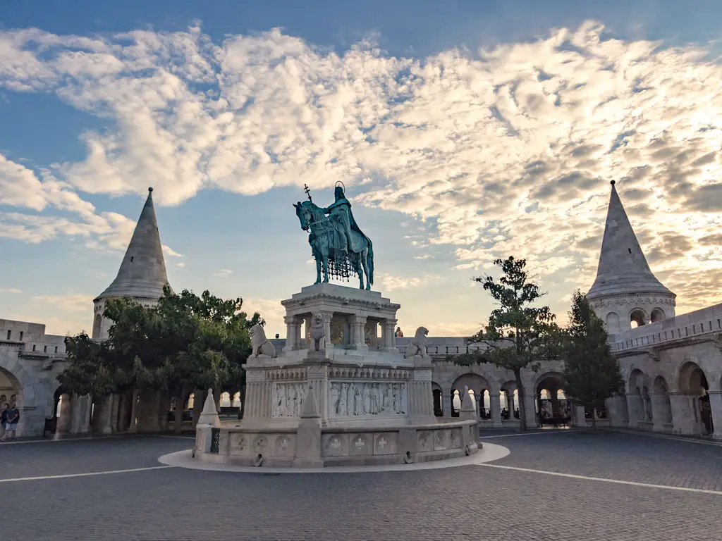 statue in front of fisherman's bastion buda castle hill budapest hungary - laugh travel eat